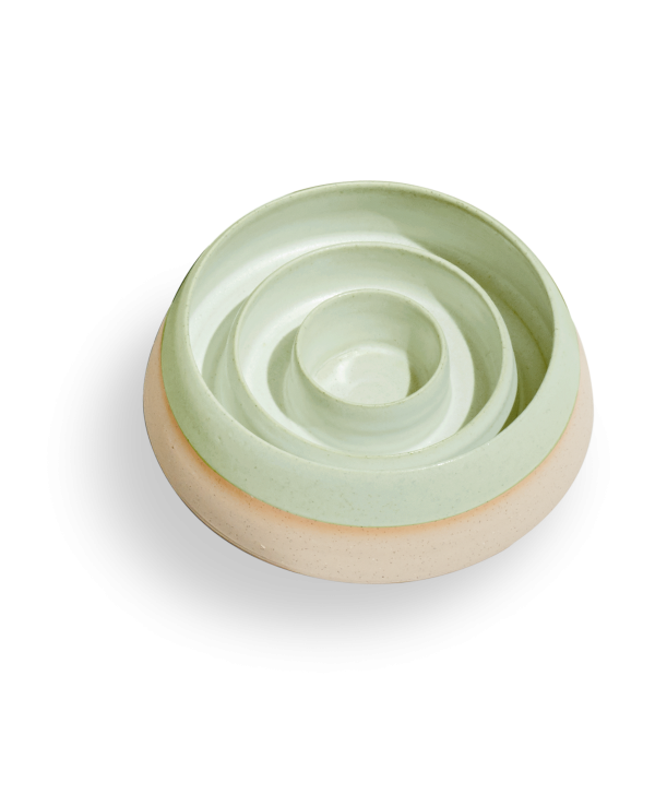 A green bowl with a circular design, perfect for serving or displaying food.