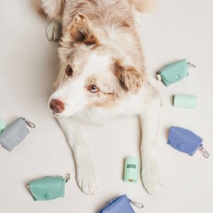 A dog resting on a white surface, encircled by tiny toys, creating a playful and adorable scene.