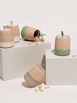 Ceramic jars with handles and a lid, perfect for storing various items.