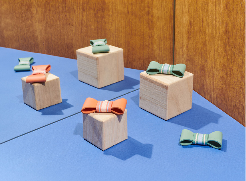 Wooden blocks with colorful bows, perfect for creative play and developing fine motor skills.